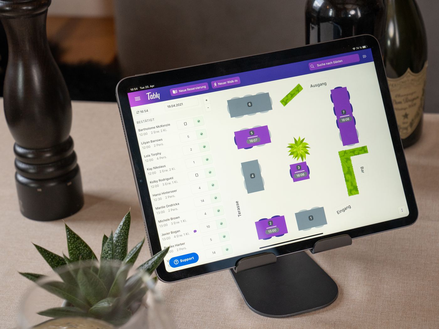 Grafischer Tischplan von Tably auf einem Tablet am gedeckten Tisch