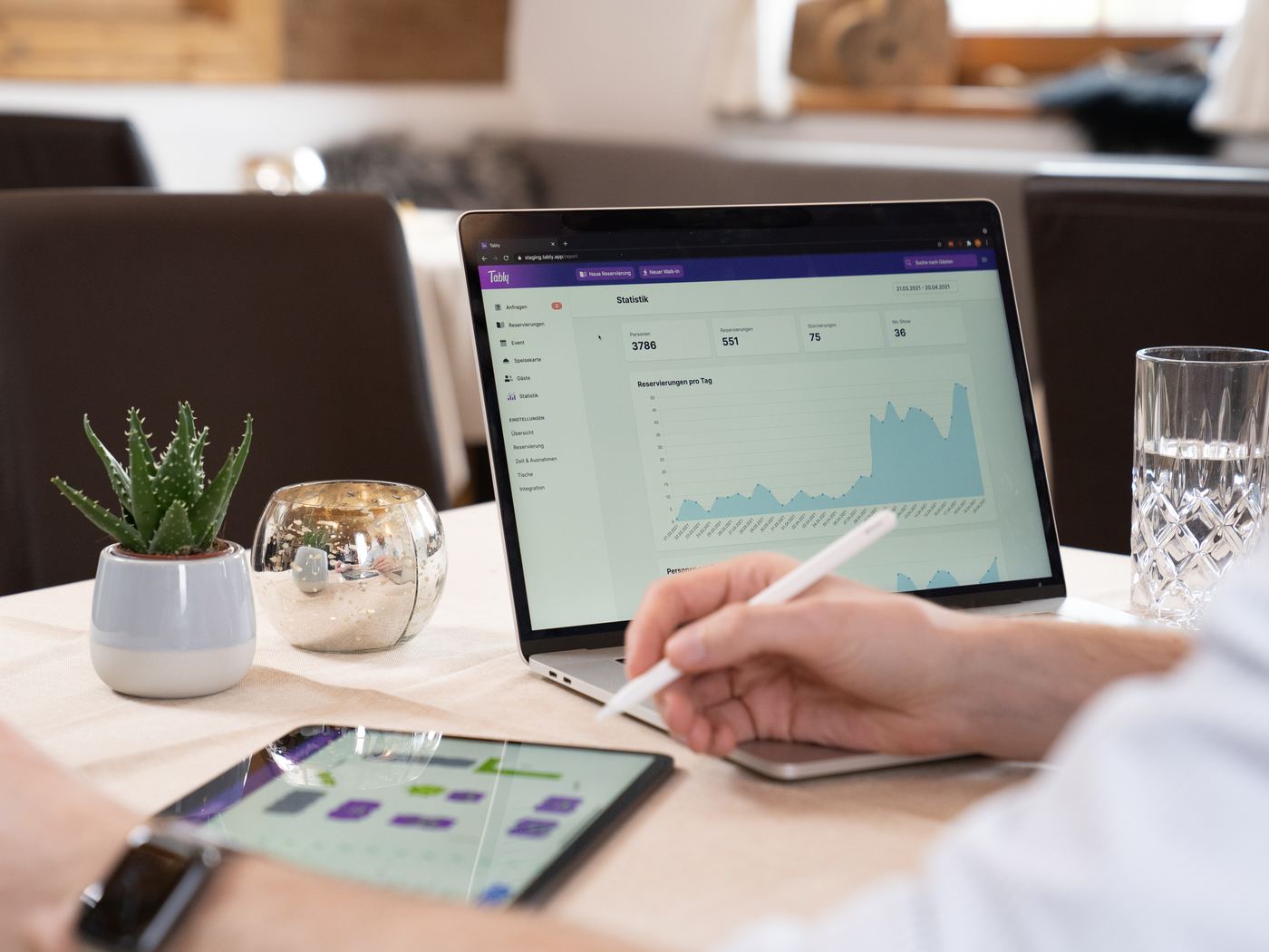 Statistiken in Tably am Laptop, daneben der Tischplan auf dem Tablet