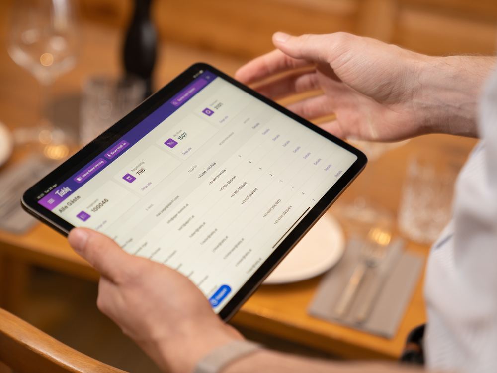 Gästeliste in Tably auf dem Tablet am gedeckten Tisch